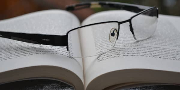 Livro aberto, com oculos sobre as paginas